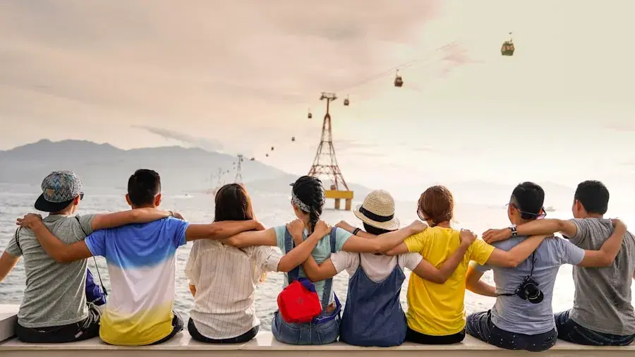 Friends sitting arm in arm, watching the sunset